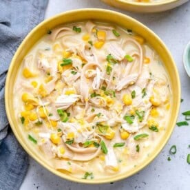a yellow round bowl filled with chicken corn soup made with noodles