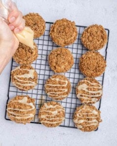adding drizzle of sugar glaze over the muffins.