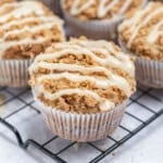 cinnamon coffee cake muffin topped with cinnamon sugar glaze on a wire rack.