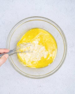 mixing the eggs, yogurt, and wet ingredients in a bowl.