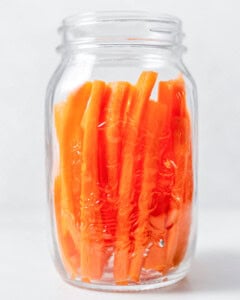 Carrot sticks placed in a jar.