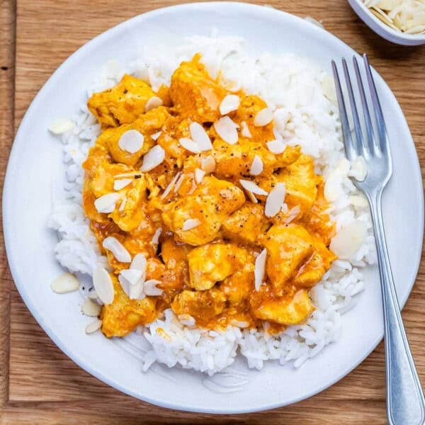 chicken korma served over white rice on a plate.
