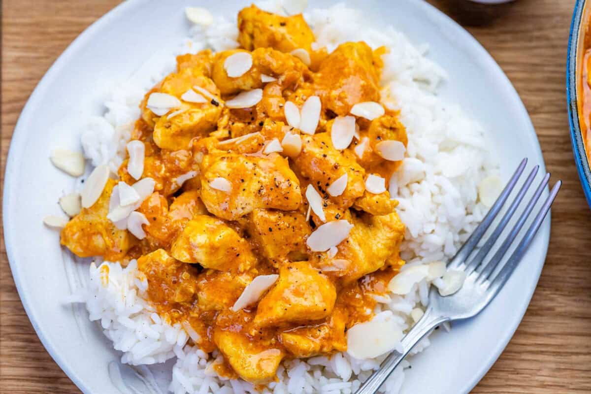 chicken korma served over a plate of rice.