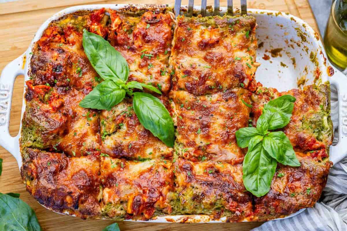chicken lasagna in a dish with a portion taken off.