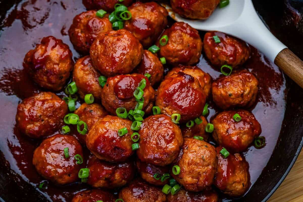 chicken meatballs in tomato jelly sauce in a pan.