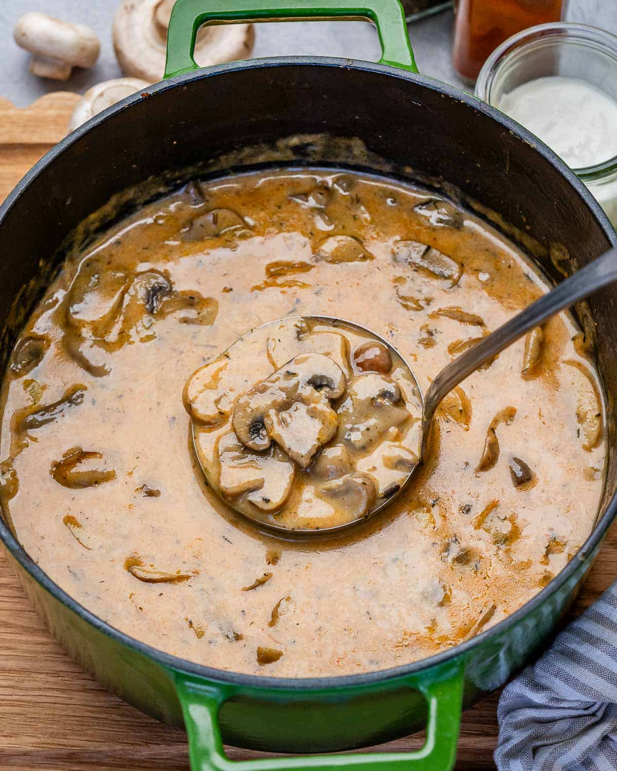 A green pot of Hungarian mushroom soup with a ladle in it