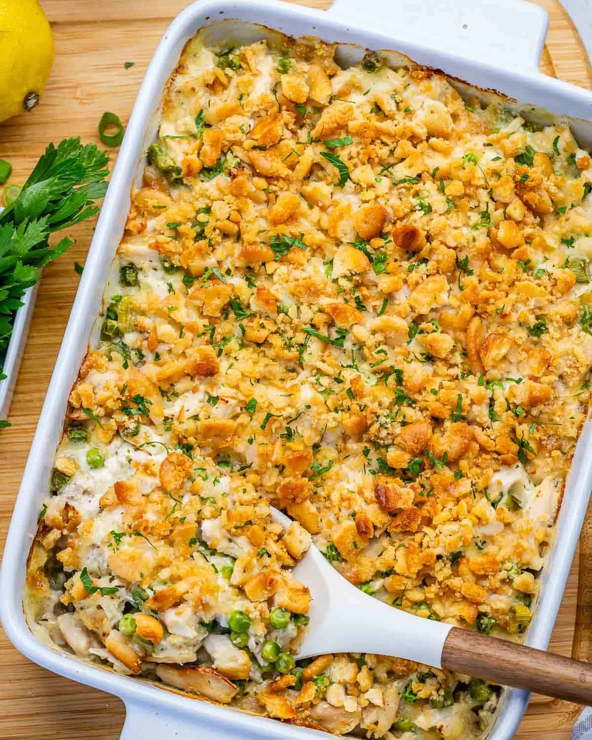 a baking dish with million dollar chicken casserole with spoon in the dish.