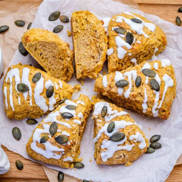 pumpkin scones cut up, baked and drizzled with sugar glaze and topped with pumpkin seeds.