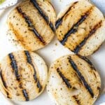 4 slices of grilled onions on a plate.