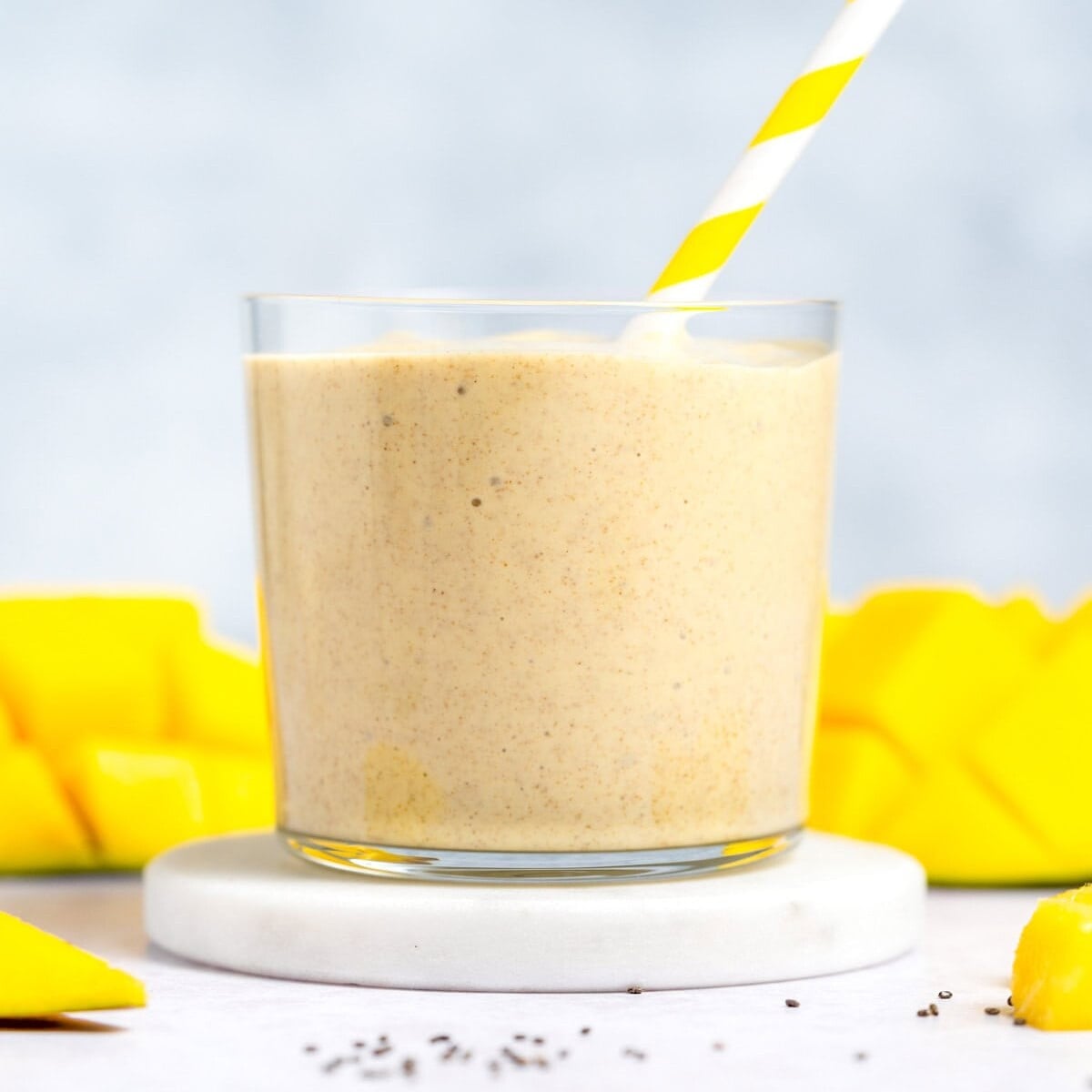 Mango smoothie in a cup with a straw in it.