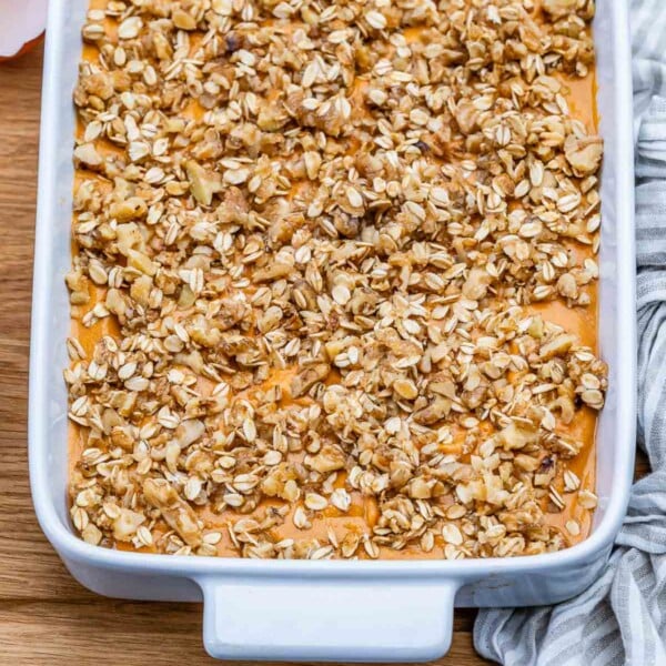 carrot souffle in a dish topped with crumbled oats.