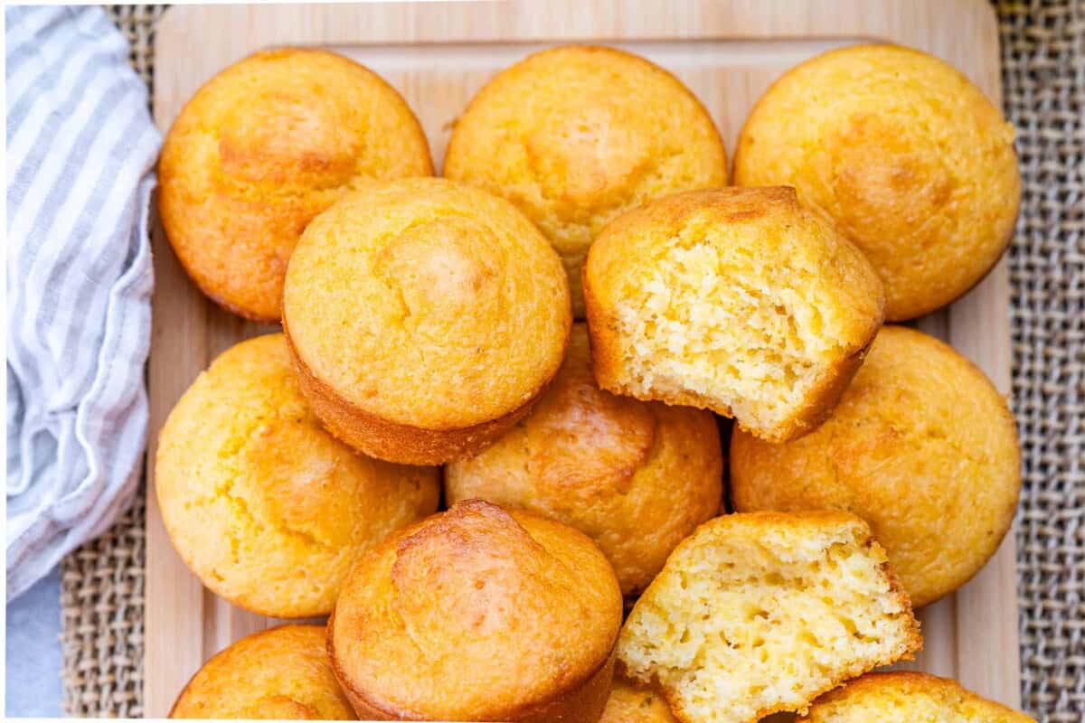 cornbread muffins together on a flat surface with one cut in half.