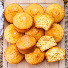 cornbread muffins stacked over each other with one muffin cut in half.