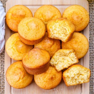 cornbread muffins stacked over each other with one muffin cut in half.