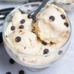 a bowl with cottage cheese ice cream with added chocolate chips and spoon in the bowl.