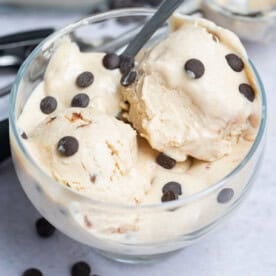 a bowl with cottage cheese ice cream with added chocolate chips and spoon in the bowl.