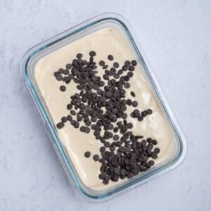 chocolate chips added over blended cottage cheese in a bowl.