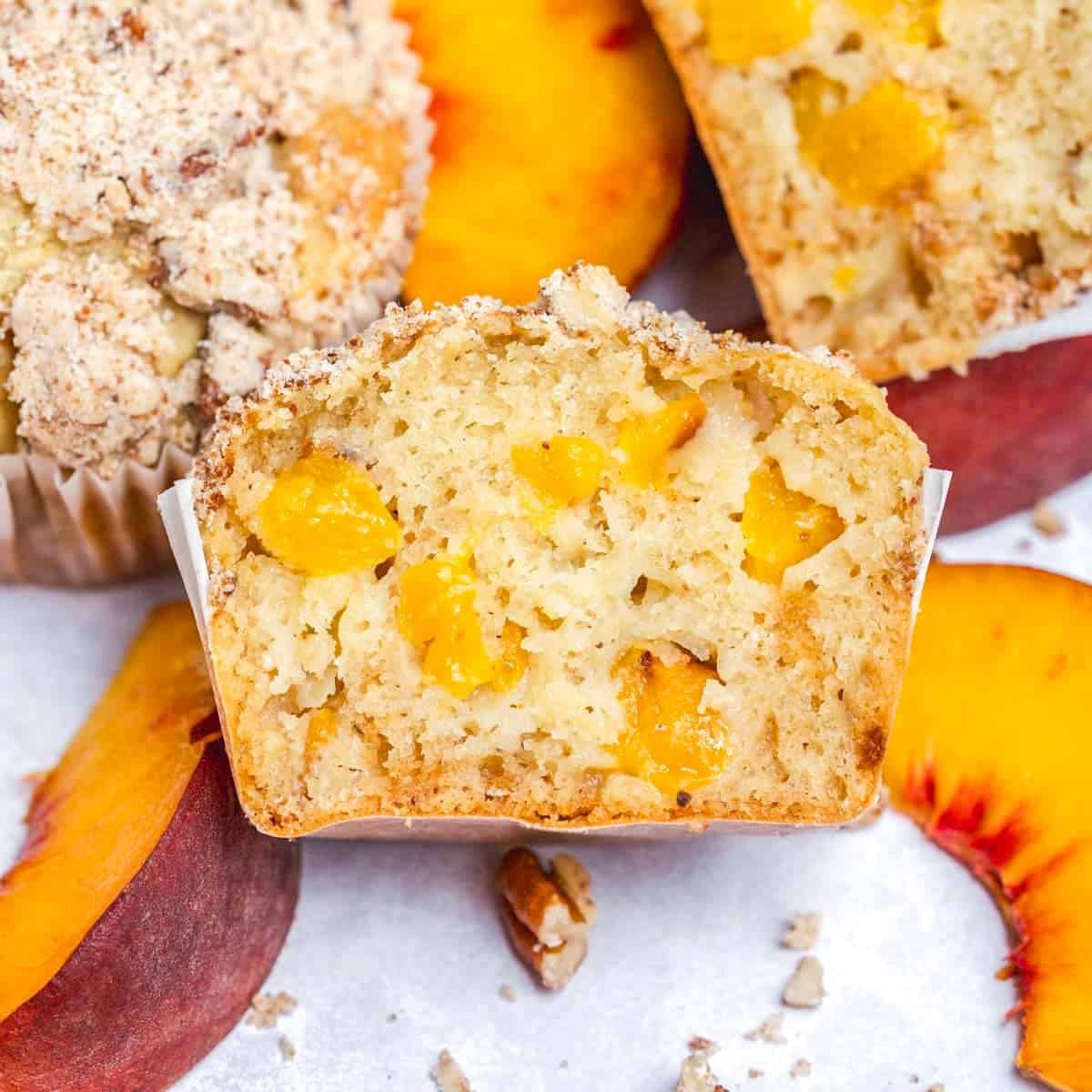 Sliced the muffin in half to show the inside of it with peach morsels.