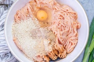 ground chicken meatball ingredients added to a bowl.