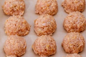 Chicken meatballs on a pan before cooking.