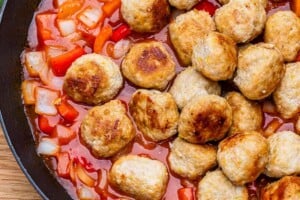 adding meatballs back into the pan with sweet and sour sauce.