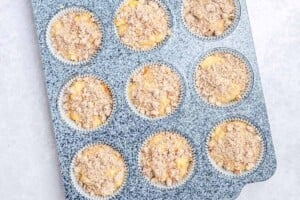 Adding muffin batter to a muffin pan.