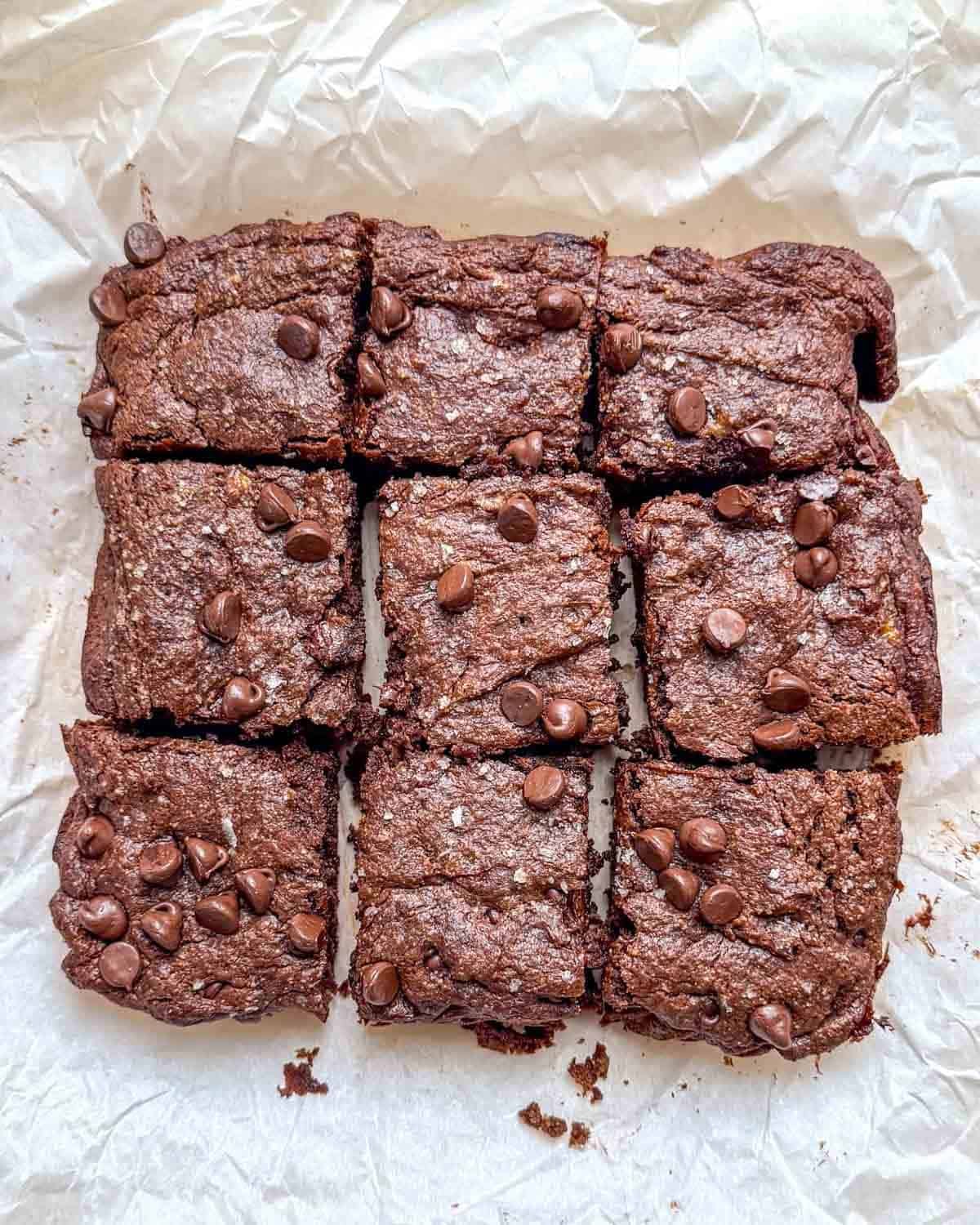 brownies cut into squares on a parchment paper.