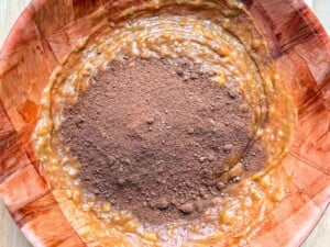 adding flour over the peanut butter mixture in a bowl.