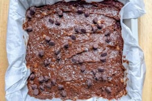 Brownie batter added to a pan.