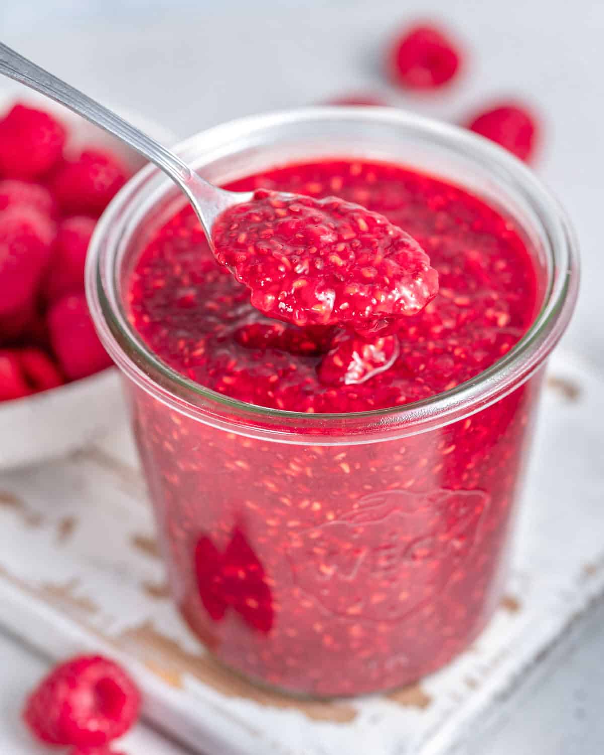 spoonful of raspberry jam in a jar.