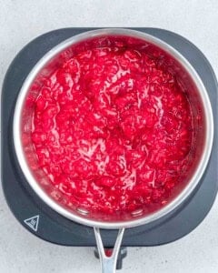 raspberries mashed in a sauce pan.