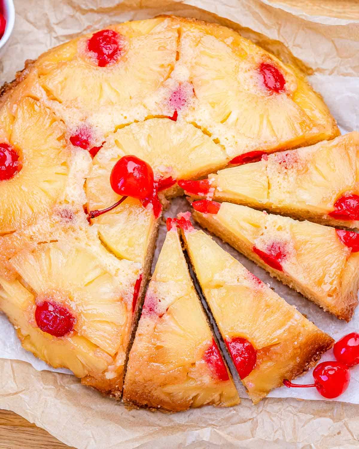 A pineapple upside-down cake with half of its slices on a flat surface.