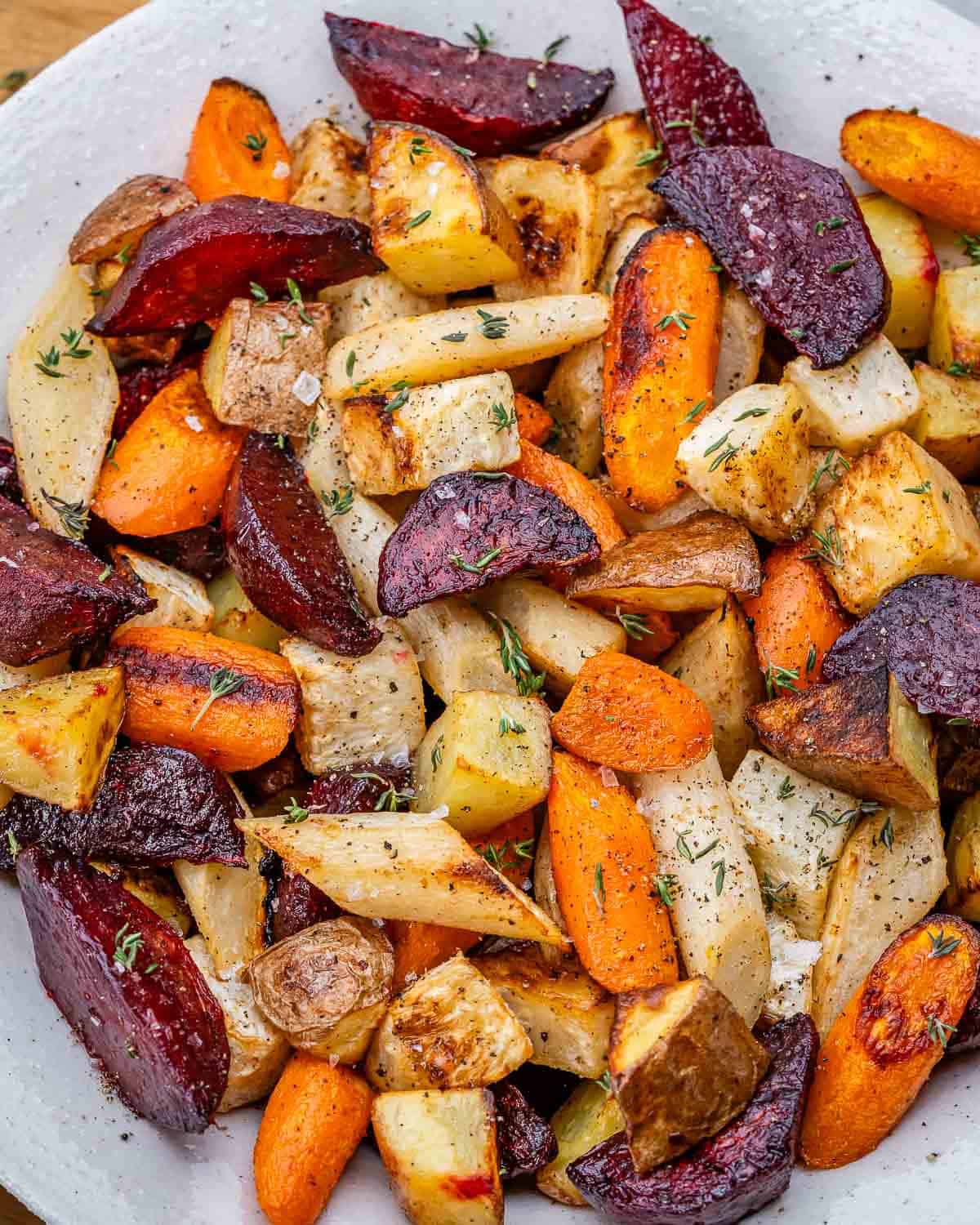 A white plate with a mixture of roasted root vegetables. 