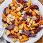 Roasted chopped root veggies served in a white round bowl.