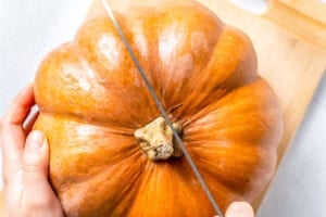 cutting the pumpkin in half.