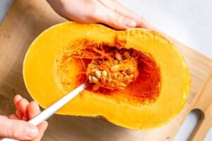 scooping the seeds out of the pumpkin.