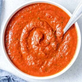 red looking ranchero sauce in a bowl with a spoon in the bowl/