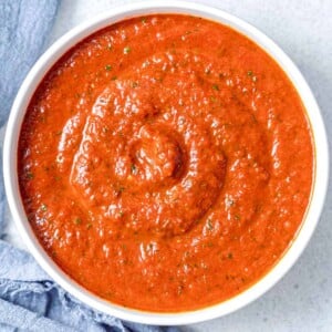 process shot of adding the sauce in a round white bowl.