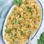 sauteed cabbage served on a plate topped with chopped parsley.