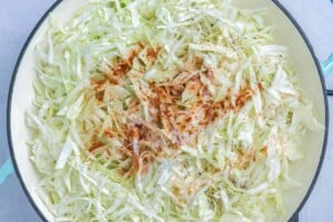seasoning added over the shredded cabbage in a pan.