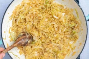 sauteed onion in a pan with wooden spoon in the pan.